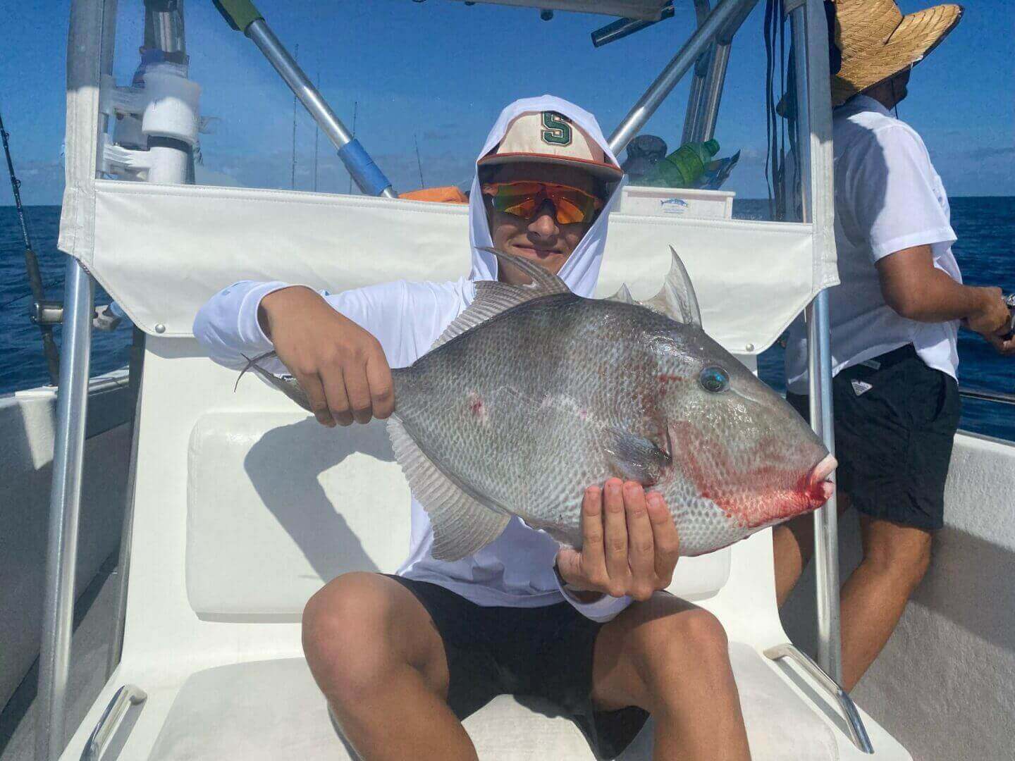Angler holding a large fish on a boat, enjoying a day with Salty Dog Fishing Charters-Johns Pass-Treasure Island.