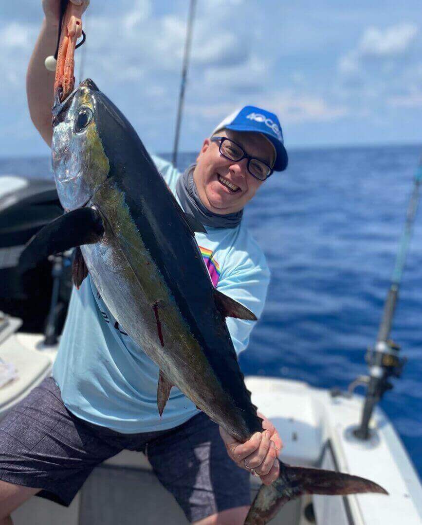 Man proudly holding a large fish on a boat, showcasing a catch with Salty Dog Fishing Charters-Johns Pass-Treasure Island.