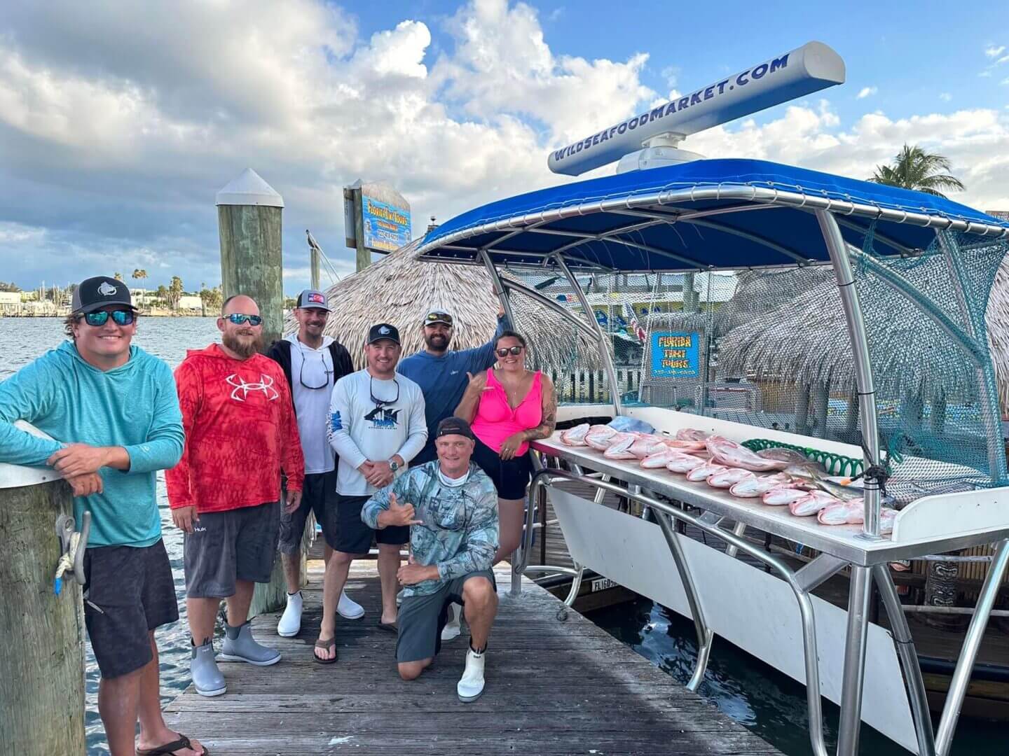 Group showing off catch on dockside with fish display, only at Salty Dog Fishing Charters-Johns Pass-Treasure Island.