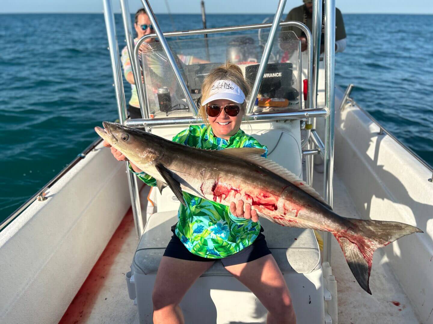 Woman holding a large fish on a boat trip, only available at Salty Dog Fishing Charters-Johns Pass-Treasure Island.