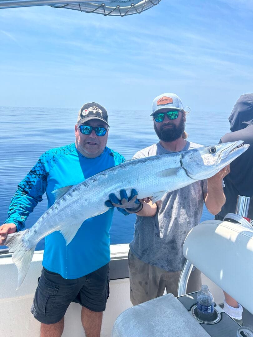 Anglers proudly display a large fish caught on a sunny day, exclusive to Salty Dog Fishing Charters-Johns Pass-Treasure Island.