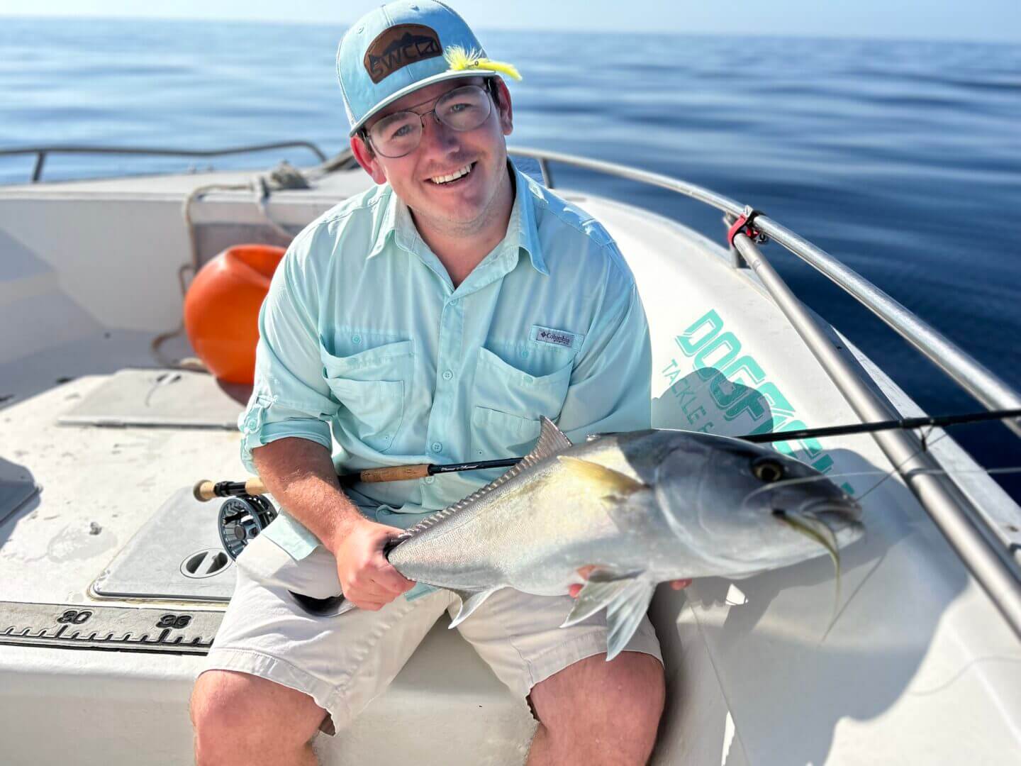 Angler holding a freshly caught fish on a boat, enjoying a sunny day with Salty Dog Fishing Charters-Johns Pass-Treasure Island.