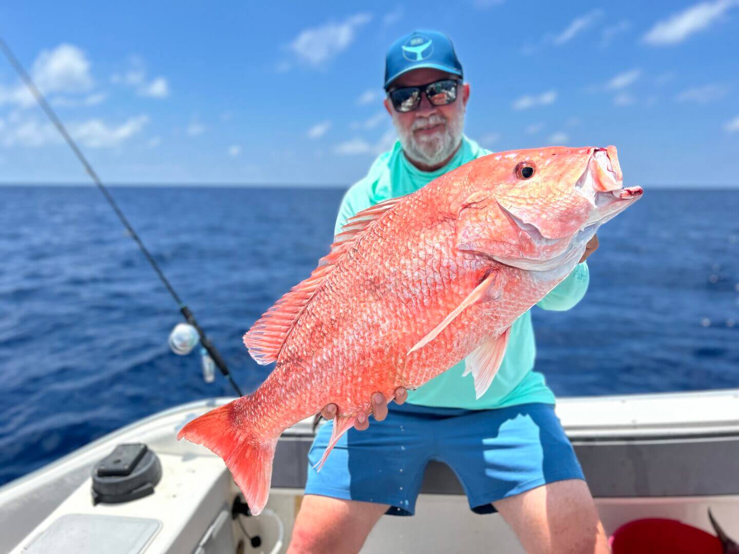 Man holding large red snapper on a fishing boat, only available at Salty Dog Fishing Charters-Johns Pass-Treasure Island.