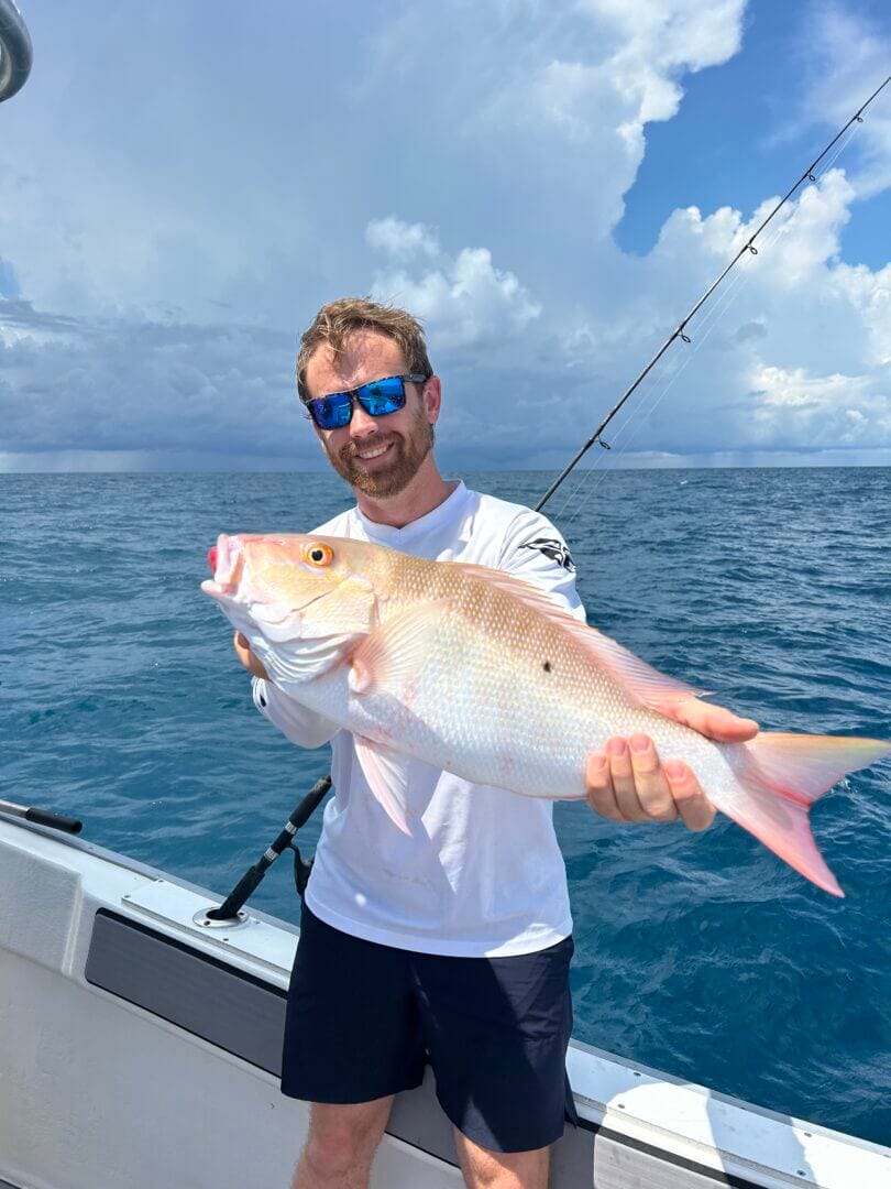 Man holding a large fish on a boat in the ocean, only available at Salty Dog Fishing Charters-Johns Pass-Treasure Island.