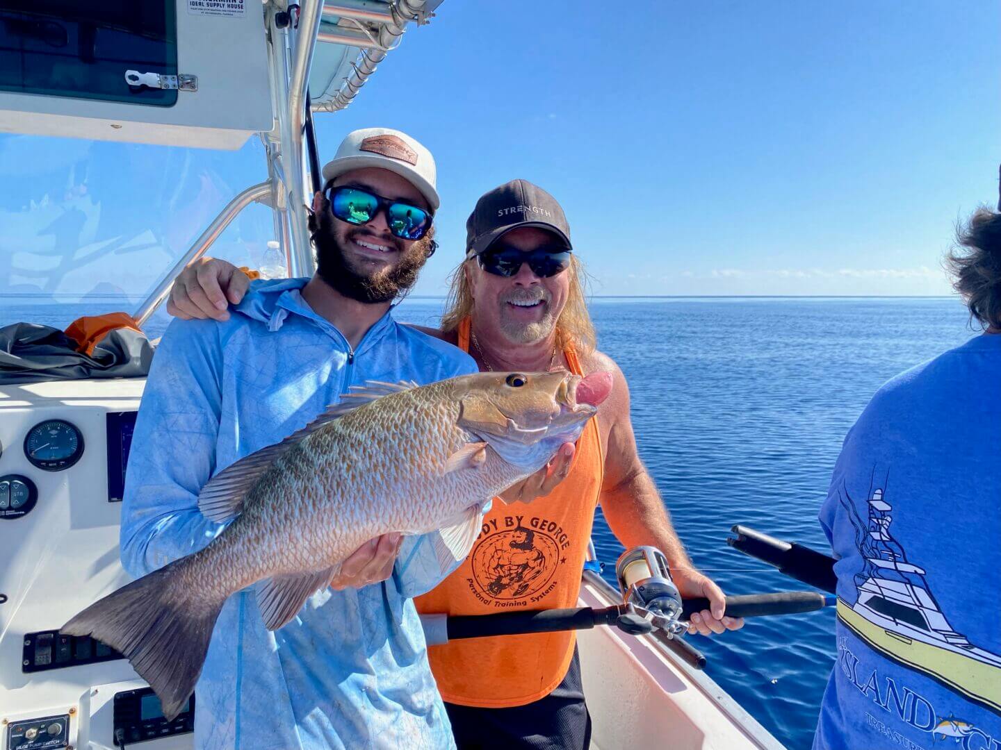 Man holding a large fish on a boat with clear blue skies, only at Salty Dog Fishing Charters-Johns Pass-Treasure Island.