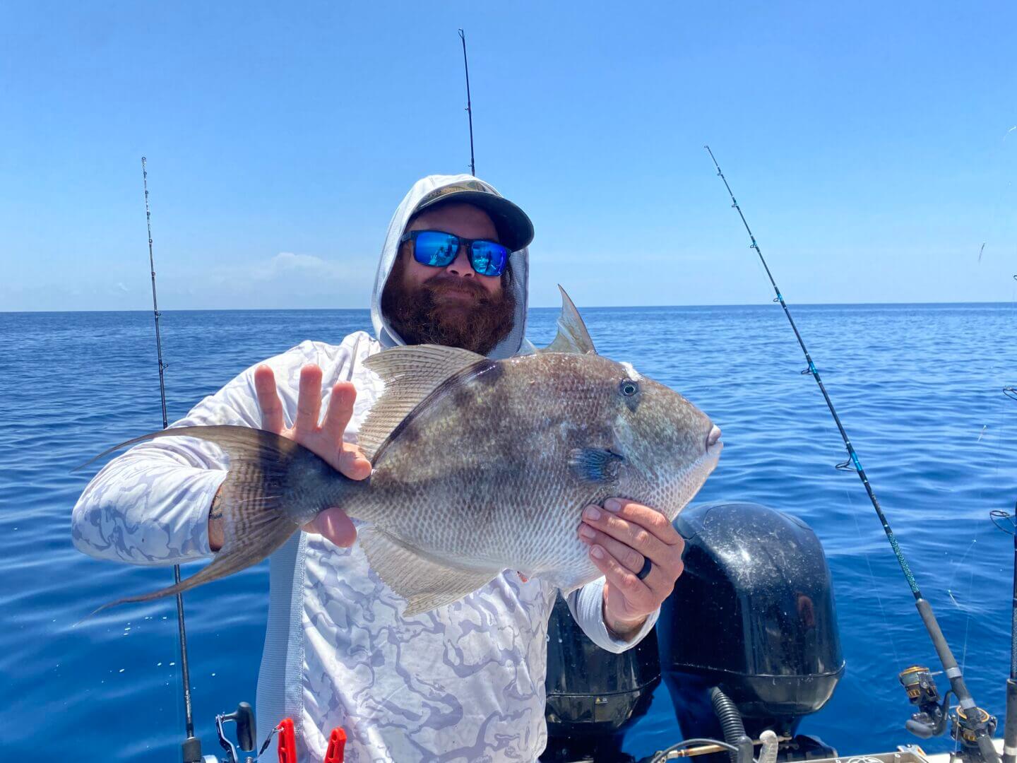 Man holding a large fish on a boat in the ocean, only available at Salty Dog Fishing Charters-Johns Pass-Treasure Island.